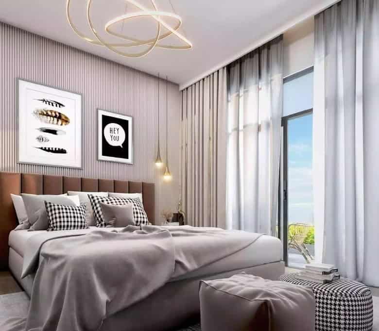 Luxurious modern bedroom interior with neutral tones, stylish artwork, and large windows offering scenic views, ideal for high-end Italian real estate by Trevi Elite.
