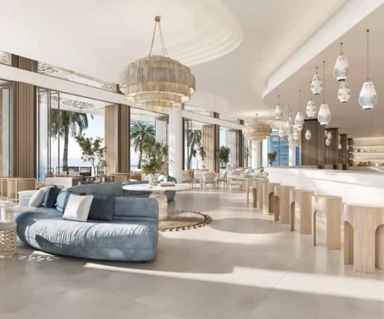 Luxurious modern hotel lobby with large windows, elegant seating, and stylish pendant lighting, offering breath-taking views and a sophisticated atmosphere.