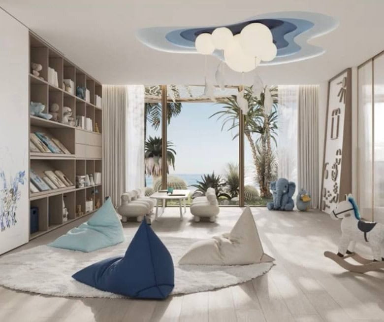 Luxurious modern living room with large glass windows showcasing a sea view, featuring playful children's decor, plush seating, and a contemporary ceiling design for an elegant Italian property.