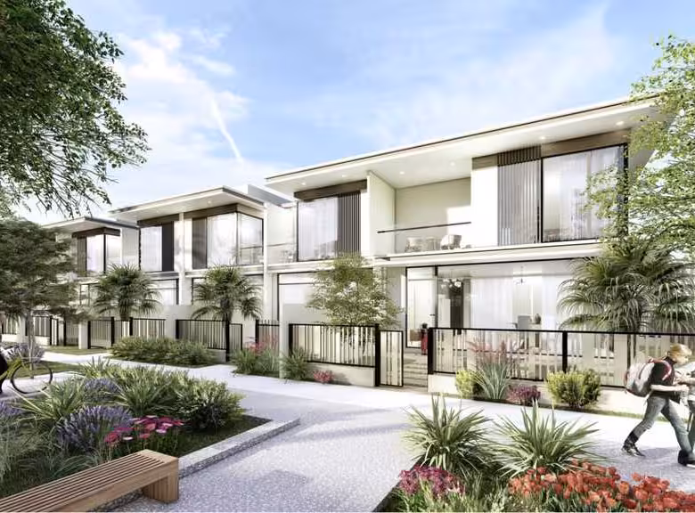 Modern townhouses with people and lush landscaping.