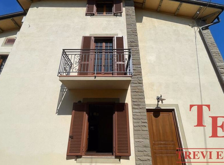 Traditional building with balcony and wooden shutters.