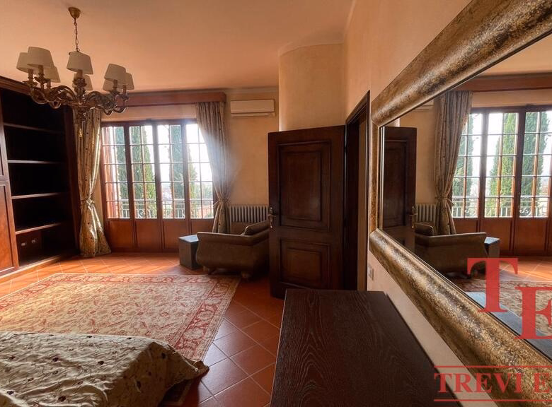 Elegant room with wooden furniture and large windows.