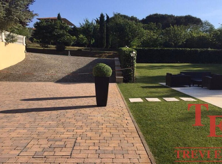 Luxurious garden with paved patio and lush greenery.