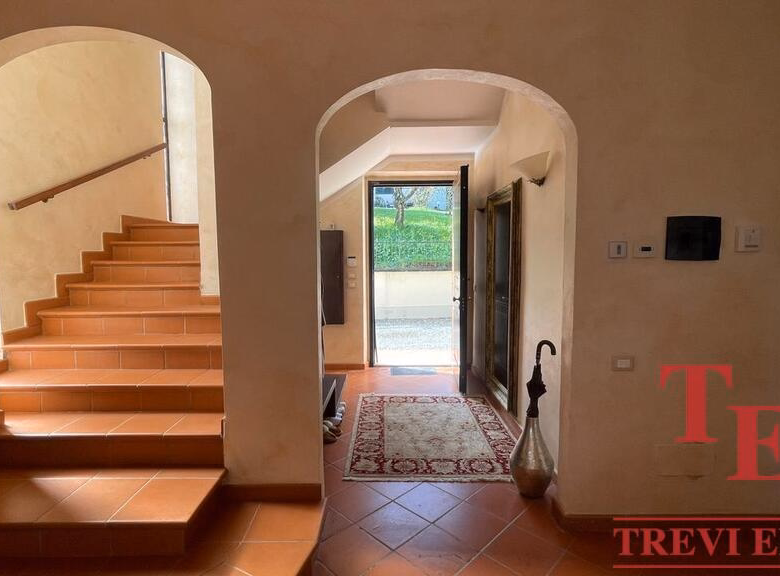 Elegant interior with terracotta staircase and arched doorways.