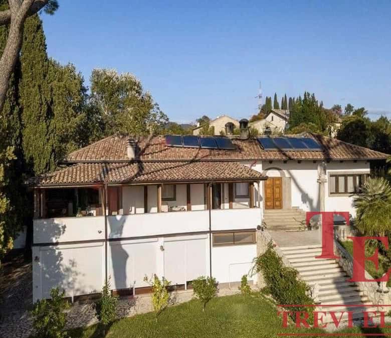 Luxurious Italian villa featuring traditional architecture and modern solar panels, nestled in lush greenery with scenic views and elegant outdoor staircases.