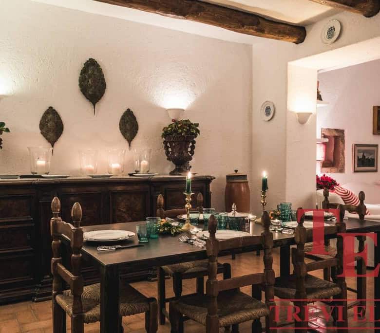 Elegant Italian dining room with rustic wooden furniture, candlelit ambiance, and traditional decor, perfect for luxurious Italian property lifestyle.