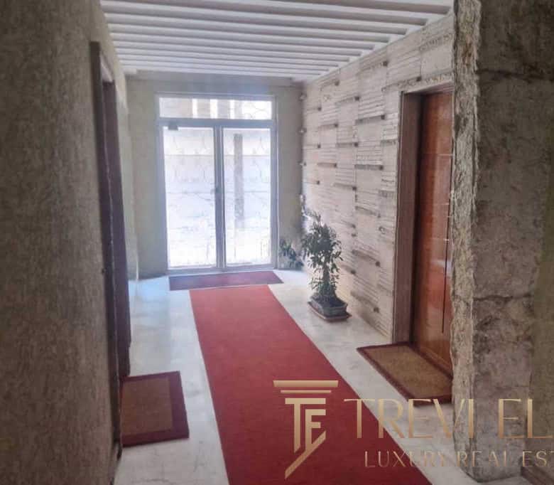 Spacious entrance hall in an upscale Italian property with modern decor, wooden accents, and natural light, offering a stylish and welcoming atmosphere.