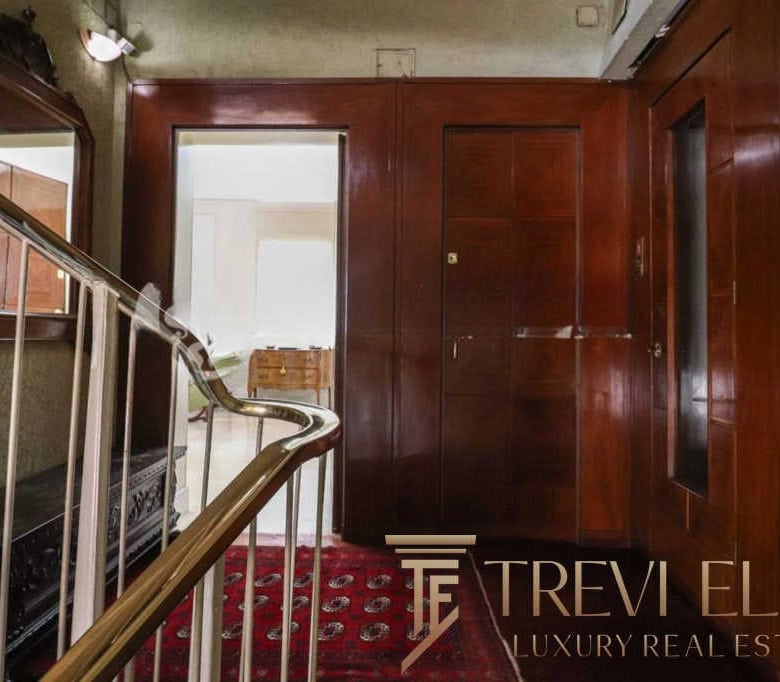 Elegant vintage wooden interior with staircase, traditional decor, and classic furnishings in a luxurious Italian property.