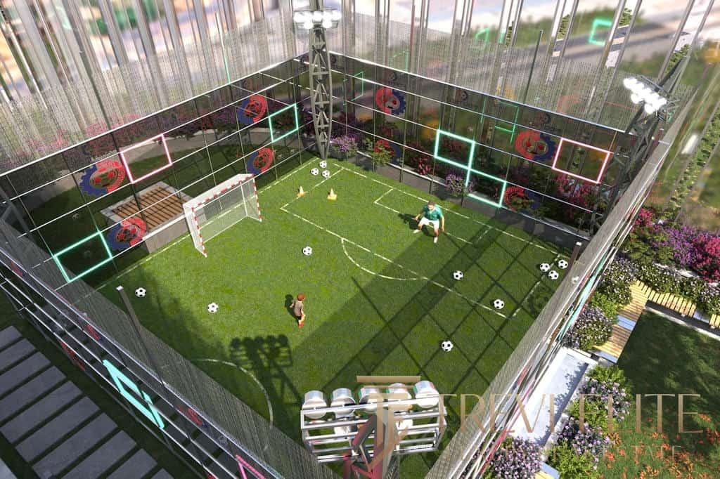 Modern rooftop football pitch with artificial grass, goalposts, and scattered soccer balls, surrounded by glass walls decorated with colourful neon lights and floral designs.