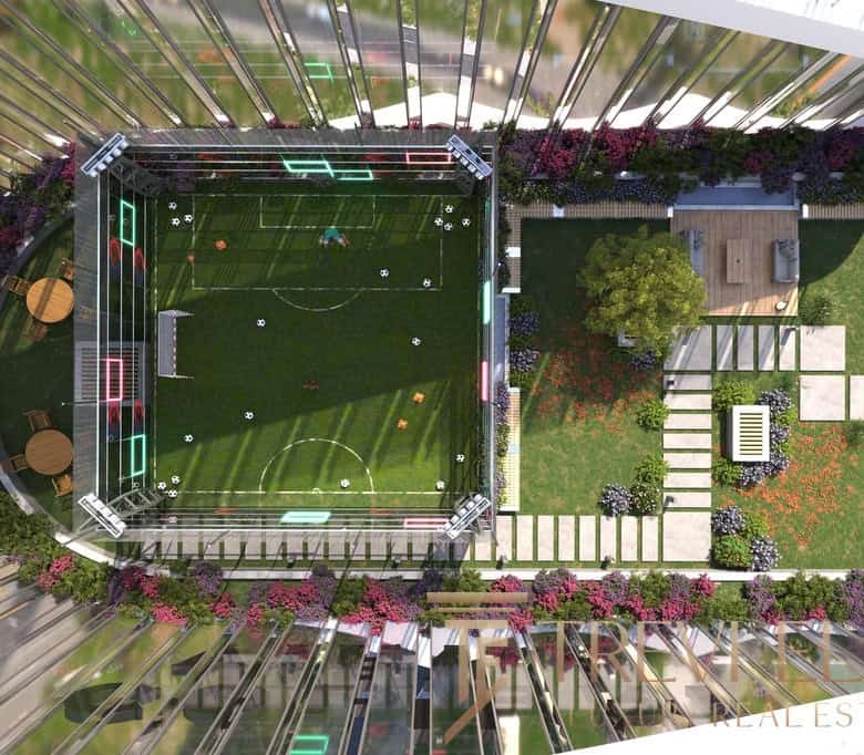 Luxurious rooftop garden with a private sports area featuring a football pitch and sentiment lights, surrounded by vibrant flowers and modern seating areas.
