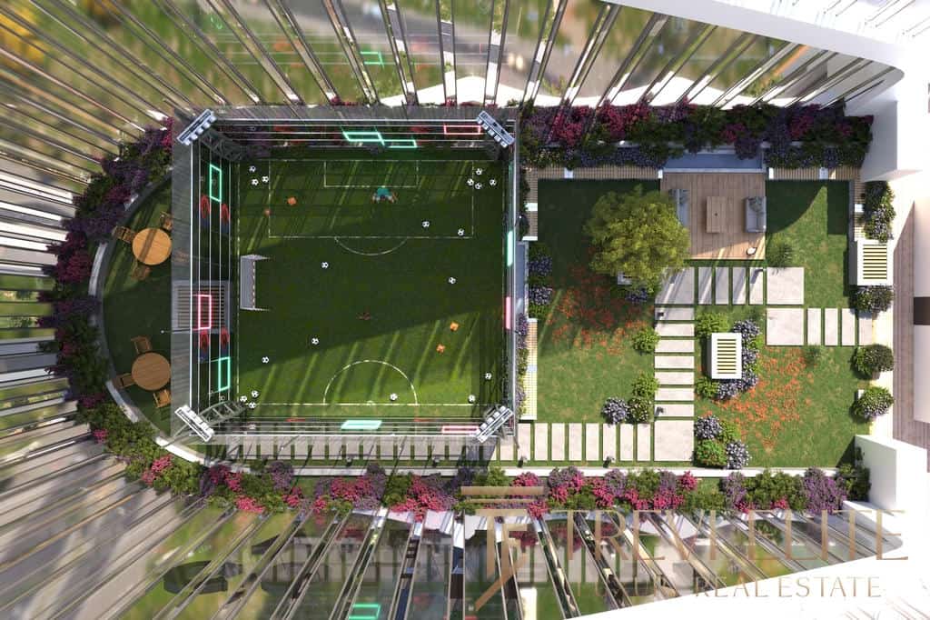 Luxurious rooftop garden with a private sports area featuring a football pitch and sentiment lights, surrounded by vibrant flowers and modern seating areas.