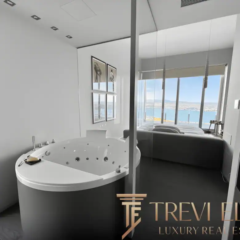 Integrated whirlpool bath positioned in front of a panoramic window.