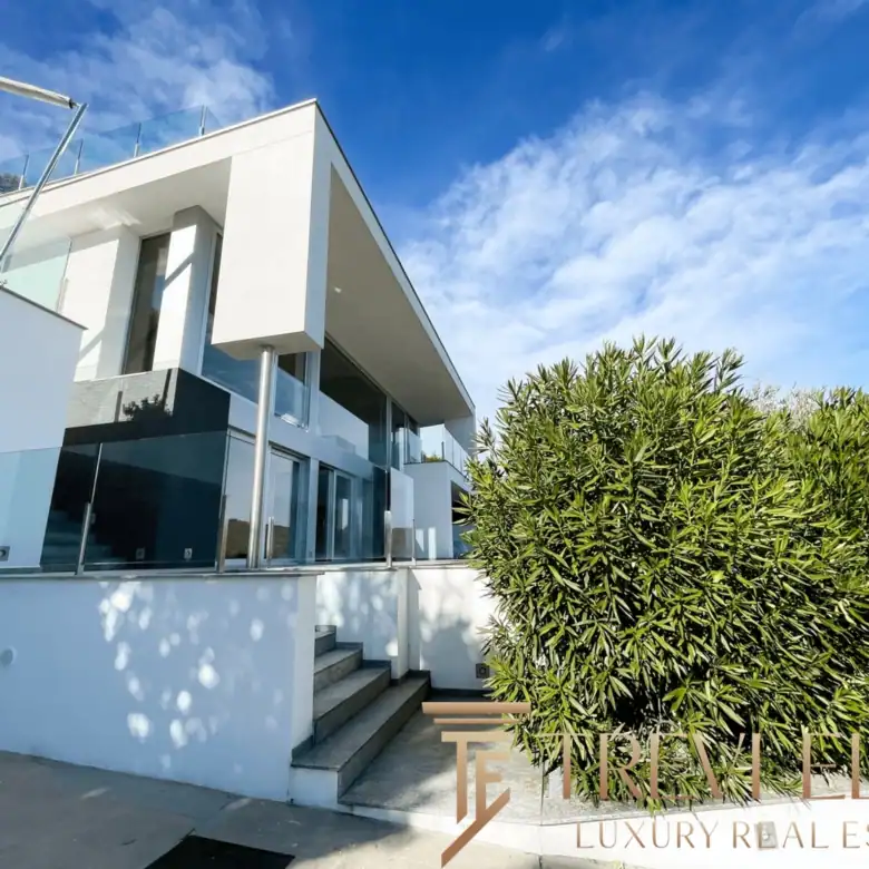 Exterior view of the villa's geometric levels and white stucco finish.