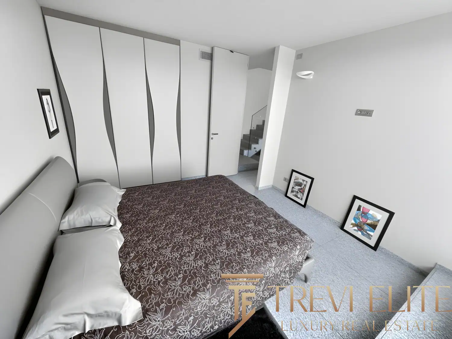 Modern walk-in closet with white cabinetry and ample storage space.