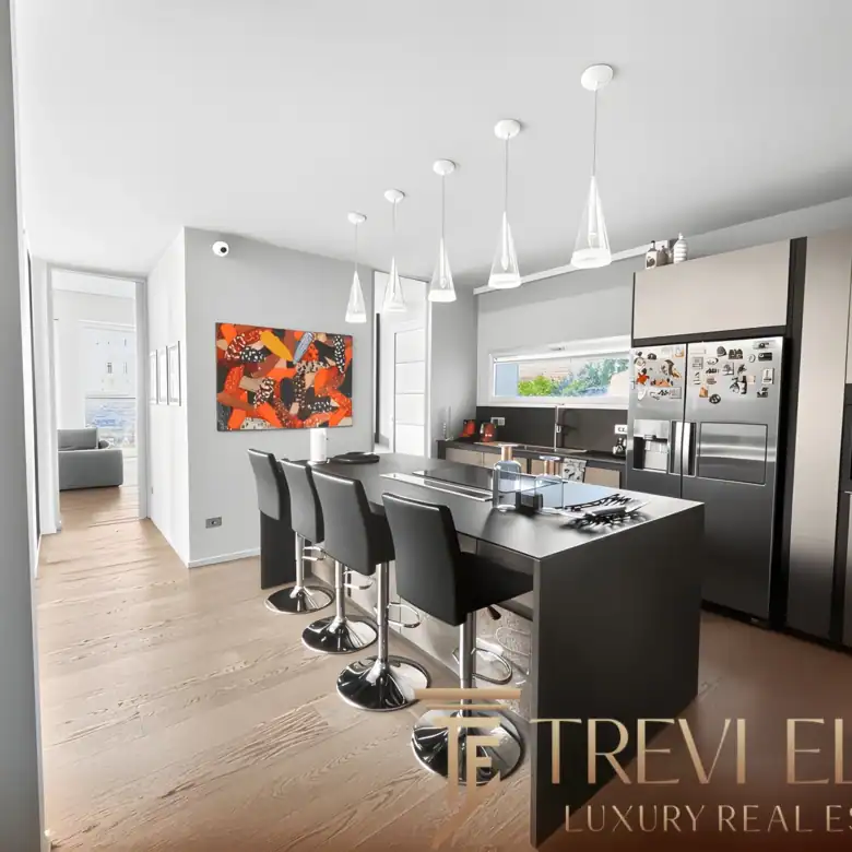 Contemporary dining room with a long table, black chairs, and lake views.