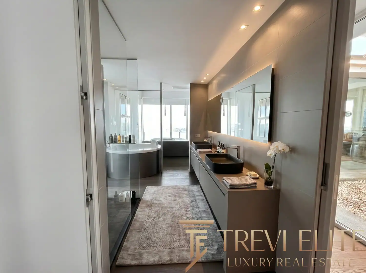 Modern bathroom with a walk-in glass shower and dual-tone tiling.
