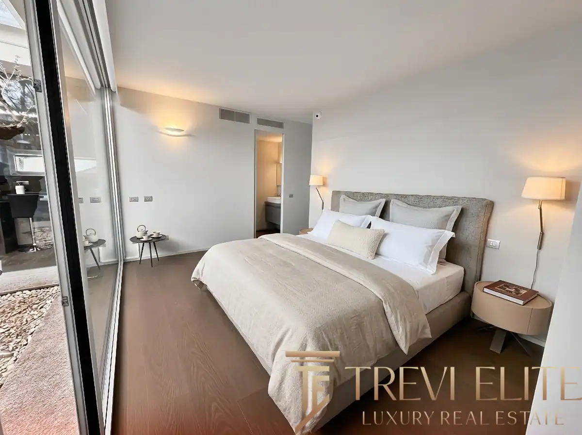 Bright bedroom with a large window and a minimalist wooden desk.