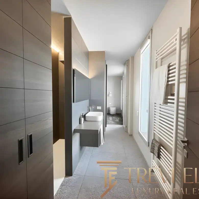 Modern hallway featuring natural oak flooring and minimalist dark wood cabinetry.