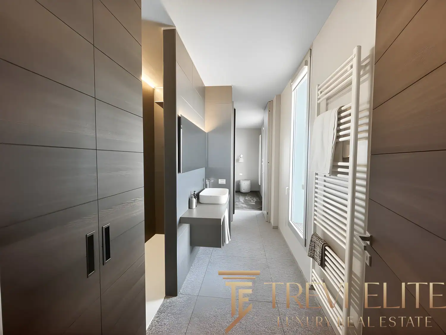 Modern hallway featuring natural oak flooring and minimalist dark wood cabinetry.