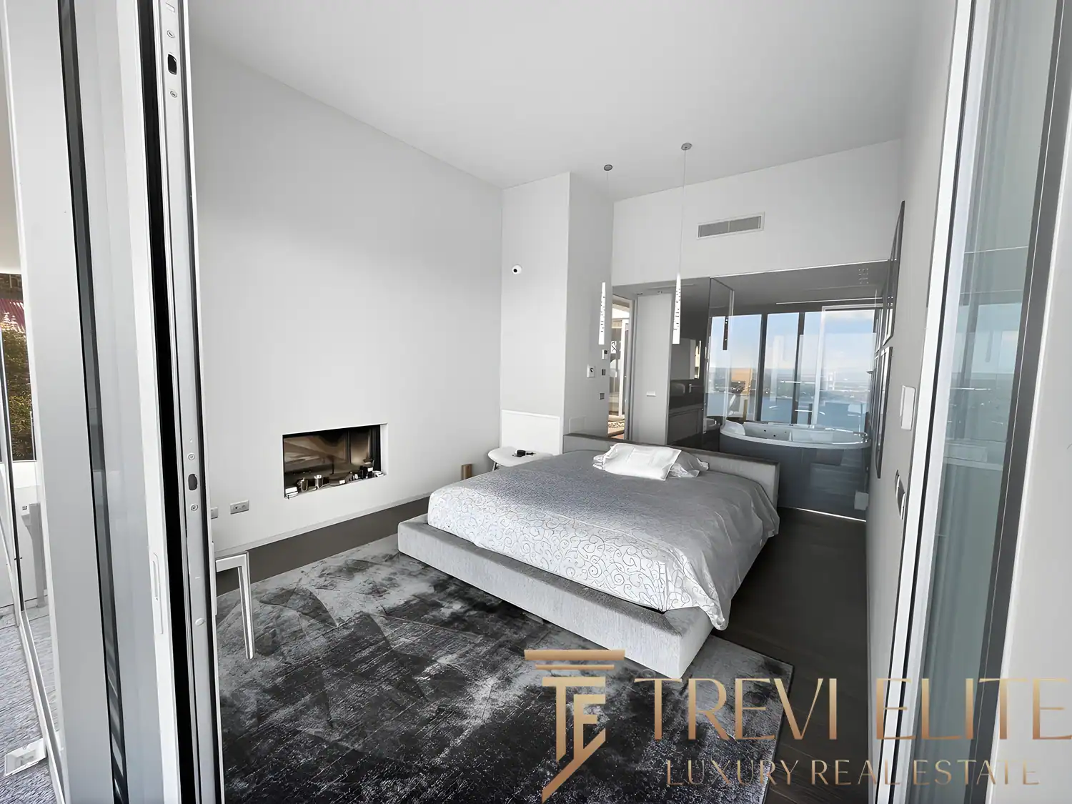 Minimalist bedroom with a built-in fireplace and grey-toned decor.